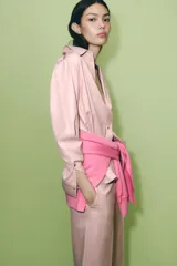 Camisa color rosa de manga larga, con cuello solapa, trabillas en los hombros, bolsillo delantero y cierre frontal con botones.