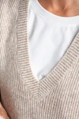 Chaleco de punto oversize con escote en V, hombros caídos y textura acanalada en color beige, confeccionado en una mezcla de acrílico, poliéster, nylon, lana y spandex.