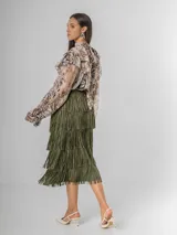 Maxi falda con múltiples capas de flecos, confeccionada en tela elastizada. Disponible en negro, beige y verde militar.