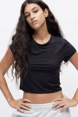Remera negra entallada de punto elástico, corte crop y cuello redondo.