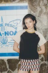 Remera colorblock con mangas ranglan color naranja, cuerpo blanco y cuello amarillo.