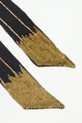 Bufanda larga color negro con lurex y lentejuelas doradas en los extremos.