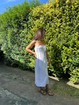 Vestido largo blanco de tirantes finos, con escote recto y detalle de puntilla en el busto.