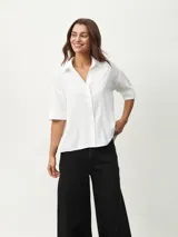 Camisa blanca de mangas cortas con textura.