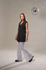 Chaleco largo negro de tela sastrera con doble fila de botones y lazo en la parte trasera.