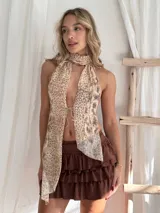 Top halter con estampado animal print en tonos beige y marrón, con cuello alto y abertura en el frente.