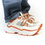 Championes urbanos blancos con detalles en naranja y cordones con patrón de rombos en blanco y naranja.