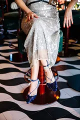 Bailarinas con puntera y talón a contraste, lentejuelas en verde y morado, raso estampado, cordón azul y borla estampada.