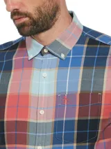 Camisa de manga larga a cuadros en tonos azul, rojo, marrón y blanco. Tiene cuello abotonado, bolsillo en el pecho y logo bordado en rojo.