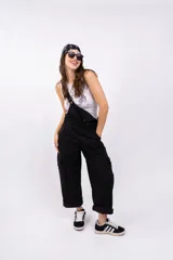 Enterito largo negro con breteles regulables, corte holgado, bolsillos laterales y ruedo arremangado.