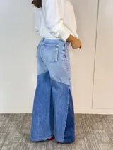 Pantalón de jean acampanado con cintura alta y diseño patchwork en tres tonos de azul.