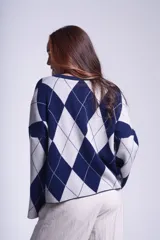 Sweater de punto con diseño de rombos en tonos marrón y beige, de mangas largas y corte holgado.