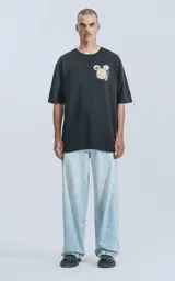 Remera negra de algodón con cuello redondo y calce oversize. Estampado en el frente con diseño de comida china y logo de Disney.