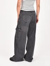 Pantalón cargo gris oscuro, de corte holgado y tiro alto, con bolsillos laterales y bolsillos cargo en las piernas.