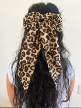 Broche para el pelo en forma de moña grande con estampado de leopardo en tonos beige y marrón.