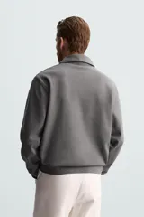 Polo manga larga negro de algodón con elasticidad y estructura. Cuello solapa con cierre frontal de botonadura y acabados con rib.