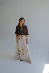 Falda larga de lino color beige con estampado floral en tonos pastel, corte amplio y cintura elastizada con cinturón de soga trenzada.