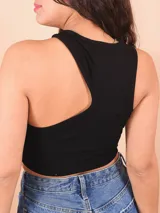 Musculosa negra de corte crop con un solo hombro y abertura en el pecho.