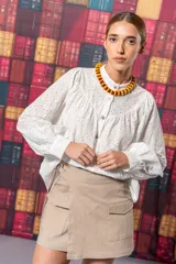 Minifalda color beige con corte irregular y bolsillos frontales con solapa.