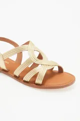 Sandalias bajas doradas con tiras finas cruzadas y hebilla en el tobillo.