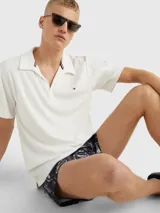 Chomba blanca de felpa de Tommy Hilfiger con cuello clásico, corte amplio, logo bordado en el pecho y detalles distintivos de la marca.