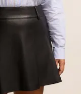 Minifalda negra de cuero sintético con pliegues, cintura alta y cierre con botón y cremallera.