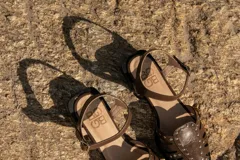 Sandalias cangrejeras color rojo con detalles de tachas doradas y correa con hebilla al tobillo.