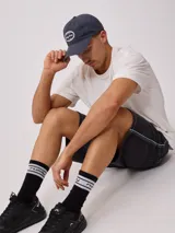 Gorra de lona lavada color azul con visera curva y parche bordado con el logo de Rusty en el frente.