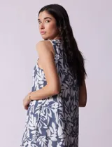 Vestido corto estampado con hojas en tonos azul y blanco, de escote halter y busto fruncido.