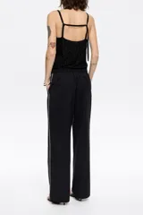 Pantalón de lana fría color negro, estilo jogger, con cintura elástica ajustable con cordón interior, bolsillos diagonales delanteros y cintas laterales decorativas.