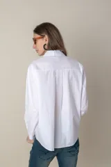 Camisa blanca de manga larga con dos bolsillos frontales con solapa.