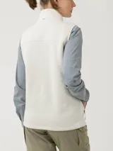 Chaleco micropolar color crudo, con cierre frontal completo, cuello alto y bolsillos laterales con cierre. Confeccionado con fibras recicladas.