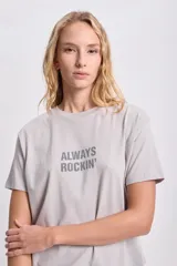 Remera gris claro de corte recto con cuello redondo y mangas cortas. Estampa frontal con la frase "Always Rockin'" en strass.