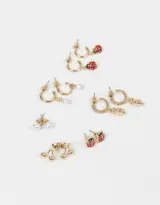 Set de seis pares de aros dorados con pasantes y argollas con dijes de frutas, perlas y strass.
