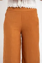 Pantalón de lino color ocre, de corte recto y tiro medio, con lazo de ajuste en la cintura.