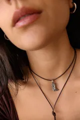 Collar doble con cordón marrón y dije de bota vaquera plateada.
