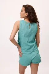 Musculosa blanca de algodón y lino, con tablas verticales en el frente y lazos laterales para regular el ajuste.