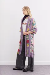 Kimono largo hasta la rodilla, de mangas 3/4 y calce amplio con tajos laterales. Diseño estampado con motivos florales y guardas.