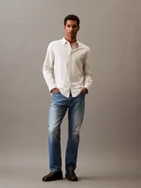 Camisa de manga larga color blanco hueso, confeccionada en lino y algodón. Tiene cuello clásico, cierre con botones y un bolsillo en el pecho.