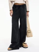 Pantalón negro de tiro alto y pierna recta, con pretina elástica y lazos ajustables.