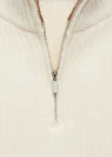 Sweater de punto grueso color crema con cuello alto con cierre de cremallera y detalle de rayas marrones en contraste en mangas y ruedo.