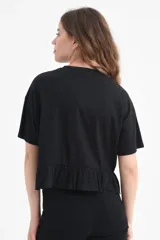 Camiseta negra de algodón orgánico con mangas cortas y volados en el ruedo.