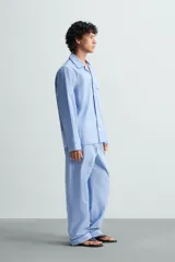 Pantalón de pijama celeste de algodón, corte relaxed fit, con cintura elástica ajustable con cordón interior, bolsillos laterales y detalle de vivos combinados a contraste en el bajo.