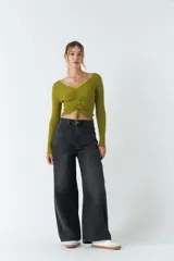 Top rojo de tejido de punto acanalado, con escote en V y mangas largas. Presenta un fruncido ajustable en el centro del frente.