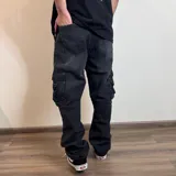 Pantalón jean cargo gris oscuro, corte holgado, con bolsillos laterales y traseros.