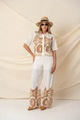 Pantalón palazzo color marfil con cintura elastizada y detalle de calado bordado color camel en el ruedo.