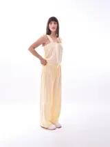 Pantalón de lino color amarillo pastel, de corte recto y tiro alto, con cintura elástica ajustable con cordón.