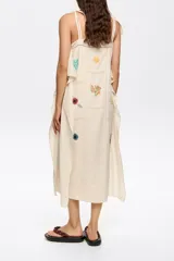 Vestido largo con estampado geométrico en tonos blanco, negro, rojo y marrón. Tiene tirantes finos y corte holgado.