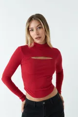 Top blanco de manga larga con cuello alto y abertura en el pecho. Corte ajustado y tejido elastizado.