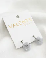 Aros de acero con dije de acrílico con forma de flor color gris.